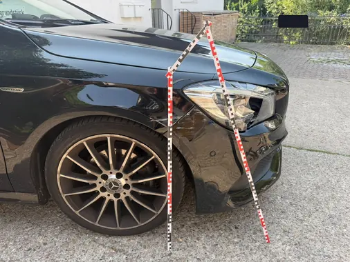Schadenvermessung mit Maßstab am Frontscheinwerfer